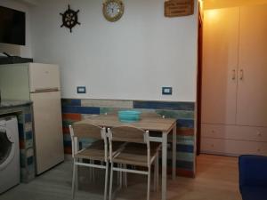 uma cozinha com mesa e cadeiras num quarto em CAMBUSA. em Acciaroli