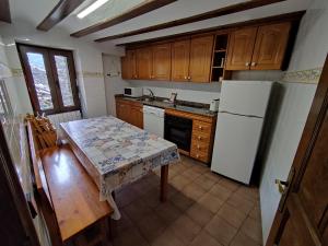 una cucina con tavolo e frigorifero bianco di Casa de la Marmota a Eriste