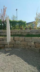 a white umbrella sitting in front of a stone wall at Ruhezeit in Stockach +4 photos
