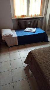 a bedroom with a bed and a window and a tile floor at Simply Home in Novara