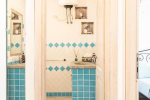 La salle de bains est pourvue de carrelage bleu et blanc. dans l'établissement IL Castello incantato, à Castelsardo