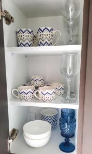 a cupboard filled with blue and white dishes and a wine glass at Stelios Studios Sougia in Sougia