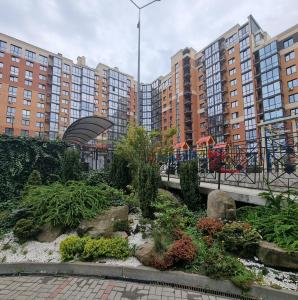 a garden in front of some tall buildings at Яровиця 2 кімнати in Lutsk