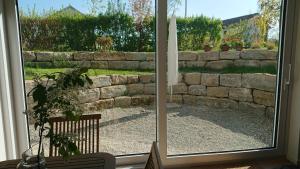 a window with a view of a stone wall at Ruhezeit in Stockach