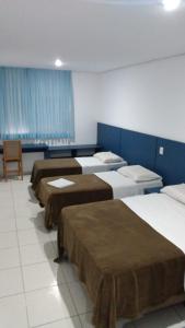 阿雷格里港的住宿－HOTEL ECONOMICO - 150m Santa Casa, Prox Assembleia e UFRGS，蓝色墙壁的房间的一排床位