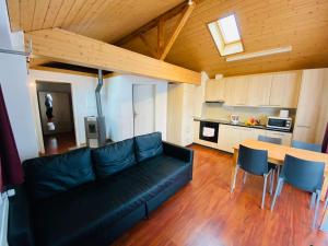 a living room with a black couch and a table at Royal Swiss Apartments in Ringgenberg