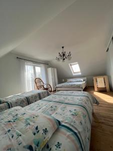een slaapkamer met 3 bedden en een kroonluchter bij Dom nad Skawą - Zator 5km in Grodzisko
