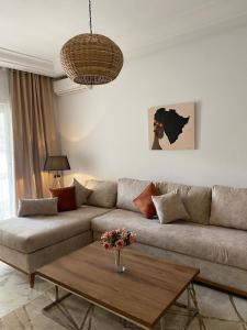 een woonkamer met een bank en een salontafel bij Appart calme & chaleureux en résidence près de la mer in Monastir