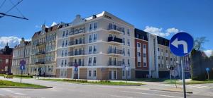 a large white building on the side of a street at Komfortowy Apartament Przy Bramie Targowej - Old Town in Elblag