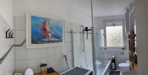 ein Badezimmer mit einem Gemälde eines Segelboots an der Wand in der Unterkunft Ankommen WOHLFüHLEN in kompletter Wohnung 2 Schlafzimmer FREi Parken TOP Anbindung A46 NETFLIX in Wuppertal