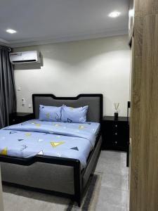 een slaapkamer met een bed met blauwe en gele kussens bij Modern City Center 3-Bed Apartment in Abuja