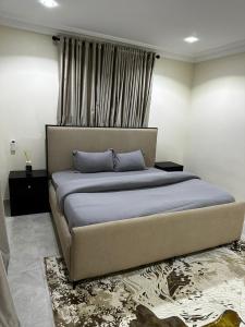 - un grand lit dans une chambre avec fenêtre dans l'établissement Modern City Center 3-Bed Apartment, à Abuja
