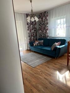 a living room with a blue couch and a mirror at Dom nad Skawą - Zator 5km in Grodzisko