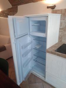 een lege koelkast met de deur open in een keuken bij Il Borgo della Leti in Bergamo