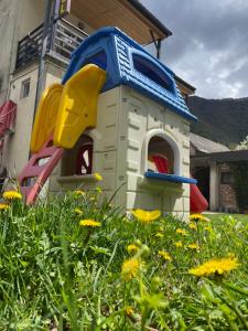 a toy dog house in a yard with flowers at Garden Hotel Pasanauri since 1892 in Passanauri