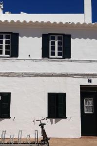 a bike parked in front of a white building at Casa típica menorquina cèntrica amb encant in Fornells