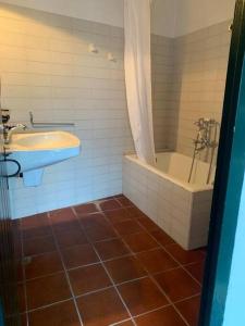 a bathroom with a tub and a sink and a bath tub at Casa típica menorquina cèntrica amb encant in Fornells
