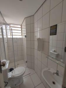 biała łazienka z toaletą i umywalką w obiekcie Hotel Caravelas w São Paulo