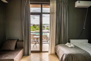 a bedroom with a bed and a view of a balcony at Tbilisi Sea Hotel in Tbilisi City +113 photos
