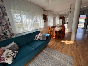 een woonkamer met een blauwe bank en een tafel bij Dom nad Skawą - Zator 5km in Grodzisko