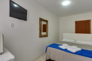 a bedroom with a bed with two towels on it at Apart Carolina in Florianópolis