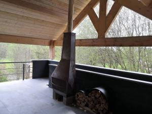 a fireplace on a screened porch with a wooden roof at Toit & Moi. in Stoumont