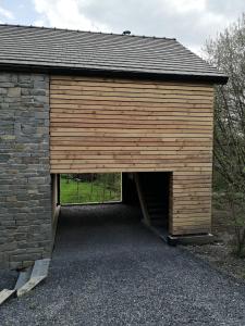 a large wooden garage with a large door at Toit & Moi. in Stoumont