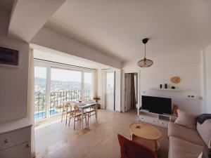 a living room with a couch and a table with chairs at İBAK Apartments in Gümüşlük