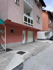 a building with a parking lot in front of it at Apartman Kasic in Konjic