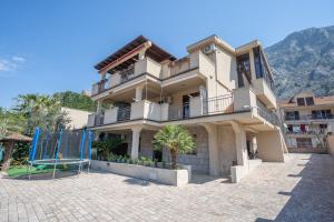 a large house with a playground in front of it at Apartments Milunović in Kotor