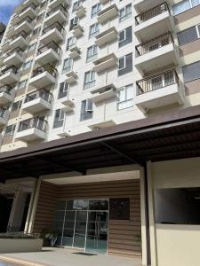 un grand immeuble d'appartements avec un garage en face de celui-ci dans l'établissement AVIDA ATRIA Tower 3, à Iloilo