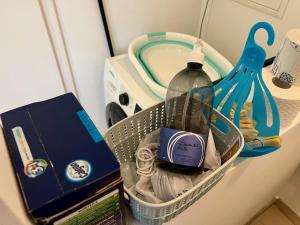 einen Wäschekorb mit einer Flasche Wasser und Handtüchern in der Unterkunft Sommerhaus Zur Eule in Klosterneuburg