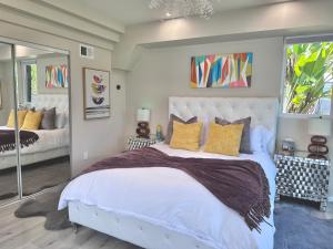 1 dormitorio con 1 cama blanca grande con almohadas amarillas en Elegant Retreat with Views Close to SF and Wine Regions en San Rafael