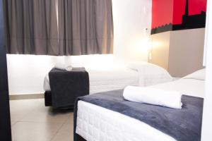 a hotel room with two beds and a suitcase at Minuano Hotel Express próx Orla Lago Guaíba, Mercado Público, 300 m Rodoviária in Porto Alegre +16 photos