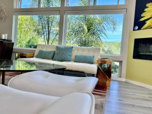 una sala de estar con muebles blancos y ventanas grandes. en Elegant Retreat with Views Close to SF and Wine Regions en San Rafael