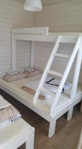 białe łóżko piętrowe w pokoju w obiekcie Domki Ewa w Sarbinowie