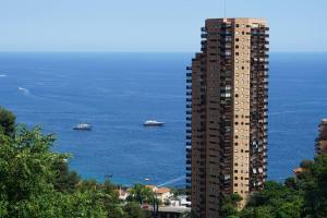 a tall building next to the ocean with boats in it at Beautiful Sea View Home Overlooking Monaco in Beausoleil