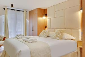 a bedroom with two beds with white sheets and a window at Luxury appartement 1BR 4P - Petits Champs in Paris
