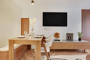 uma sala de jantar com uma mesa e uma televisão na parede em Luxury appartement 1BR 4P - Petits Champs em Paris