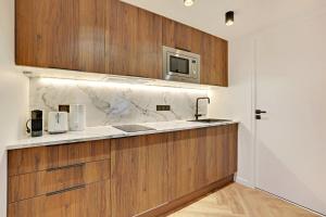 a kitchen with wooden cabinets and a microwave at Luxury appartement 1BR 4P - Petits Champs in Paris