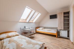 um quarto com 2 camas, uma mesa e uma televisão em Willa Diana- z panoramą jeziora i gór w Polańczyku em Polańczyk
