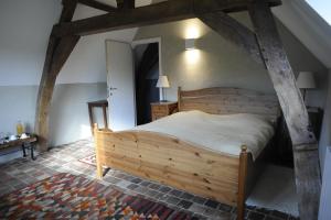 um quarto com uma cama de madeira num quarto em La ferme aux oiseaux B&B em Beaumont
