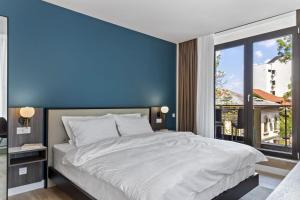 a bedroom with a large bed with a blue wall at Uni88 Apart Hotel in Bucharest
