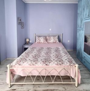 a bedroom with a bed with a pink bedspread at Tararas apartments in Nea Michaniona