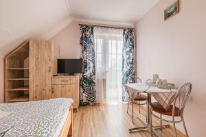 um quarto com uma cama e uma mesa com cadeiras em Willa Diana- z panoramą jeziora i gór w Polańczyku em Polańczyk