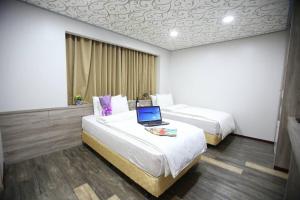 新竹市にある心園生活旅店 Xin Yuan Hotelのホテルルーム ベッド2台&ノートパソコン付 +24枚の写真