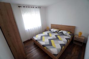 a bedroom with a bed and a window at Apartman Petra in Brodarica