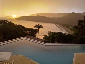 una piscina con vista sull'oceano di Panoramica Residencial a Barequeçaba