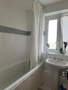 a bathroom with a tub and a sink and a bath tub at A taste of Camberwell & Dulwich! in London