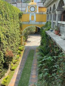 a walkway with a clock on a building at Ciudad Vieja Bed & Breakfast Hotel in Guatemala